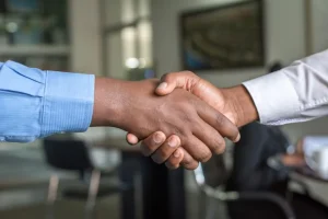 Personas estrechando manos en una mesa para nota de politica nacional