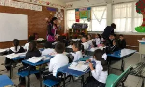 Maestra y estudiantes en un aula de educación primaria en México