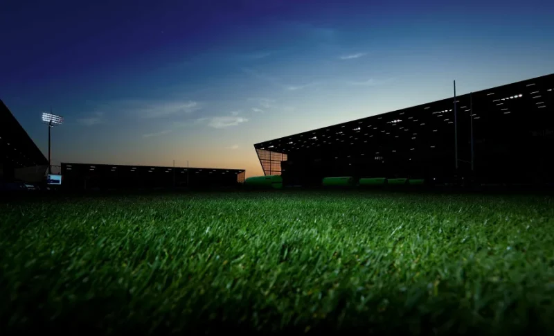 Cancha de estadio con césped al atardecer