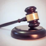 Mazo de justicia sobre una mesa como referencia a denuncia y proceso legal