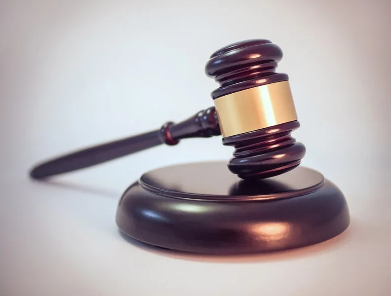 Mazo de justicia sobre una mesa como referencia a denuncia y proceso legal