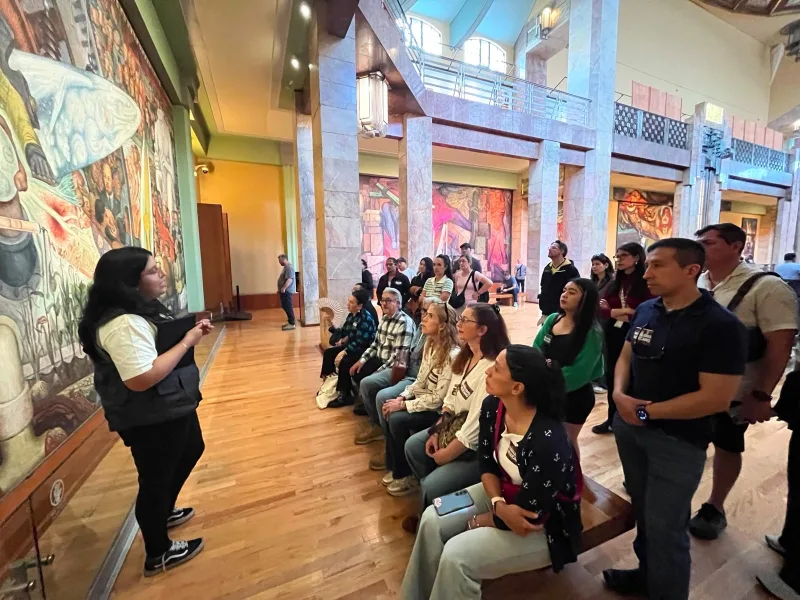 Visitantes recorren murales del Palacio de Bellas Artes durante actividad cultural