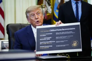 Donald Trump muestra un documento sobre recomendaciones de vacunacion infantil en Estados Unidos