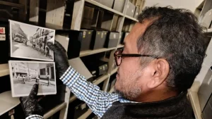Archivista revisa fotografías históricas en un acervo