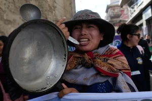 Una maestra sostiene una olla vacía durante una protesta en La Paz